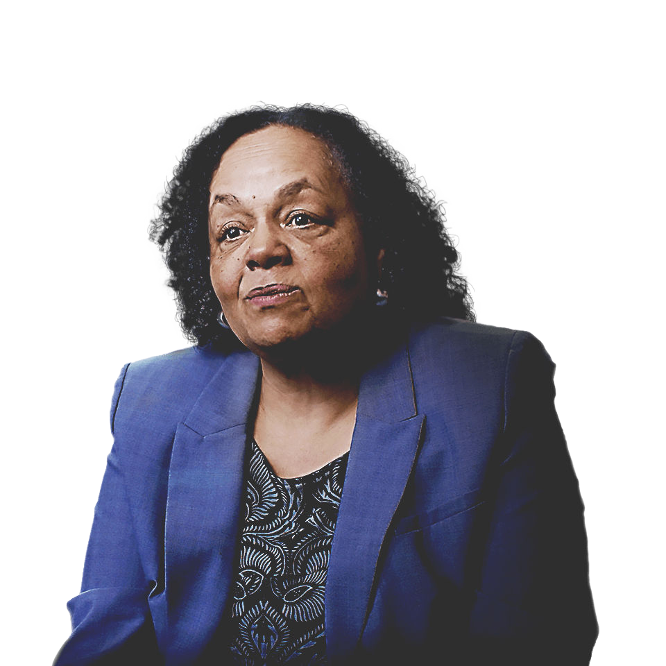 Darlene Flynn, directora ejecutiva de Raza y Equidad de Oakland, con una chaqueta azul sentada frente a un paisaje urbano