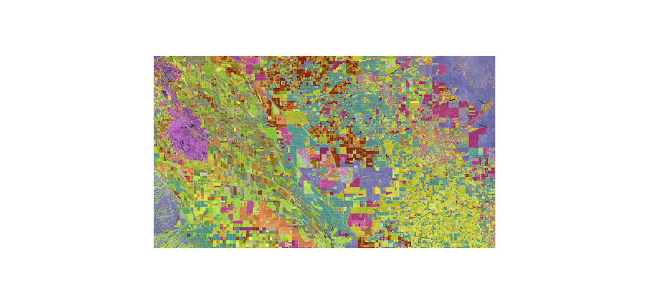 Una imagen aérea azul, verde, roja y rosa en que se identifican parcelas de tierra