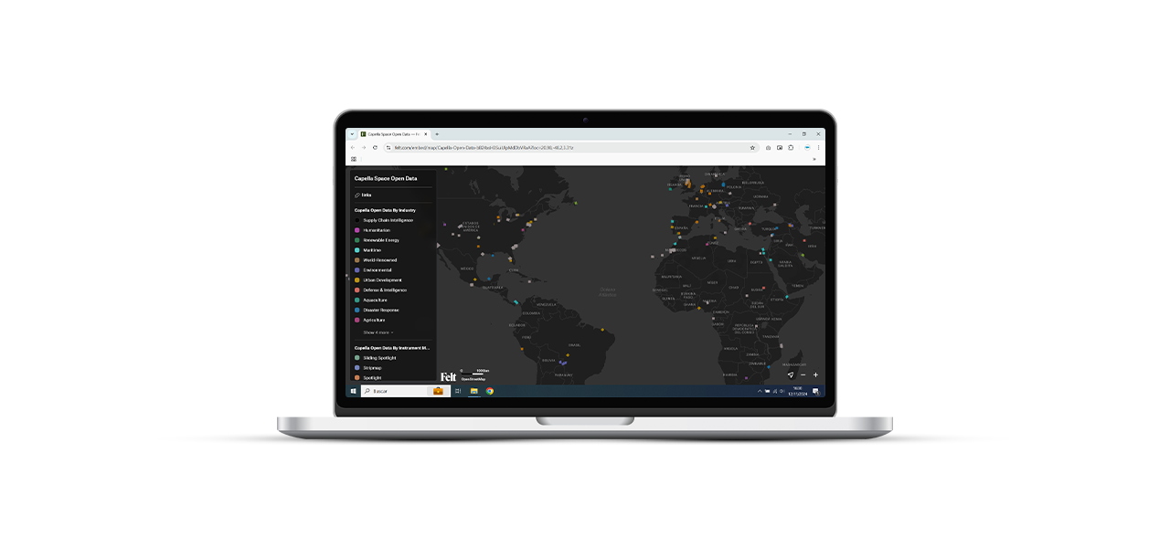 Dos personas que llevan ropa de invierno y equipo de seguridad naranja quitando la nieve acumulada a lo largo de una carretera transitada