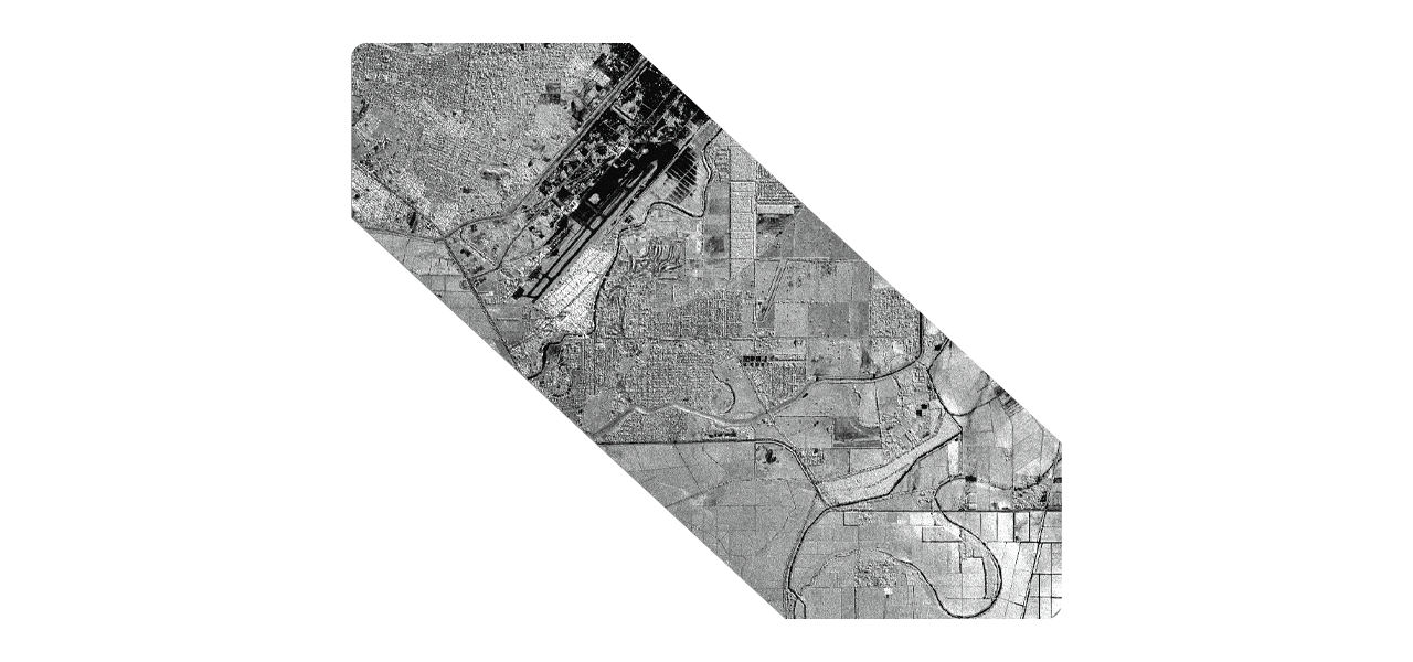 Dos personas que llevan ropa de invierno y equipo de seguridad naranja quitando la nieve acumulada a lo largo de una carretera transitada