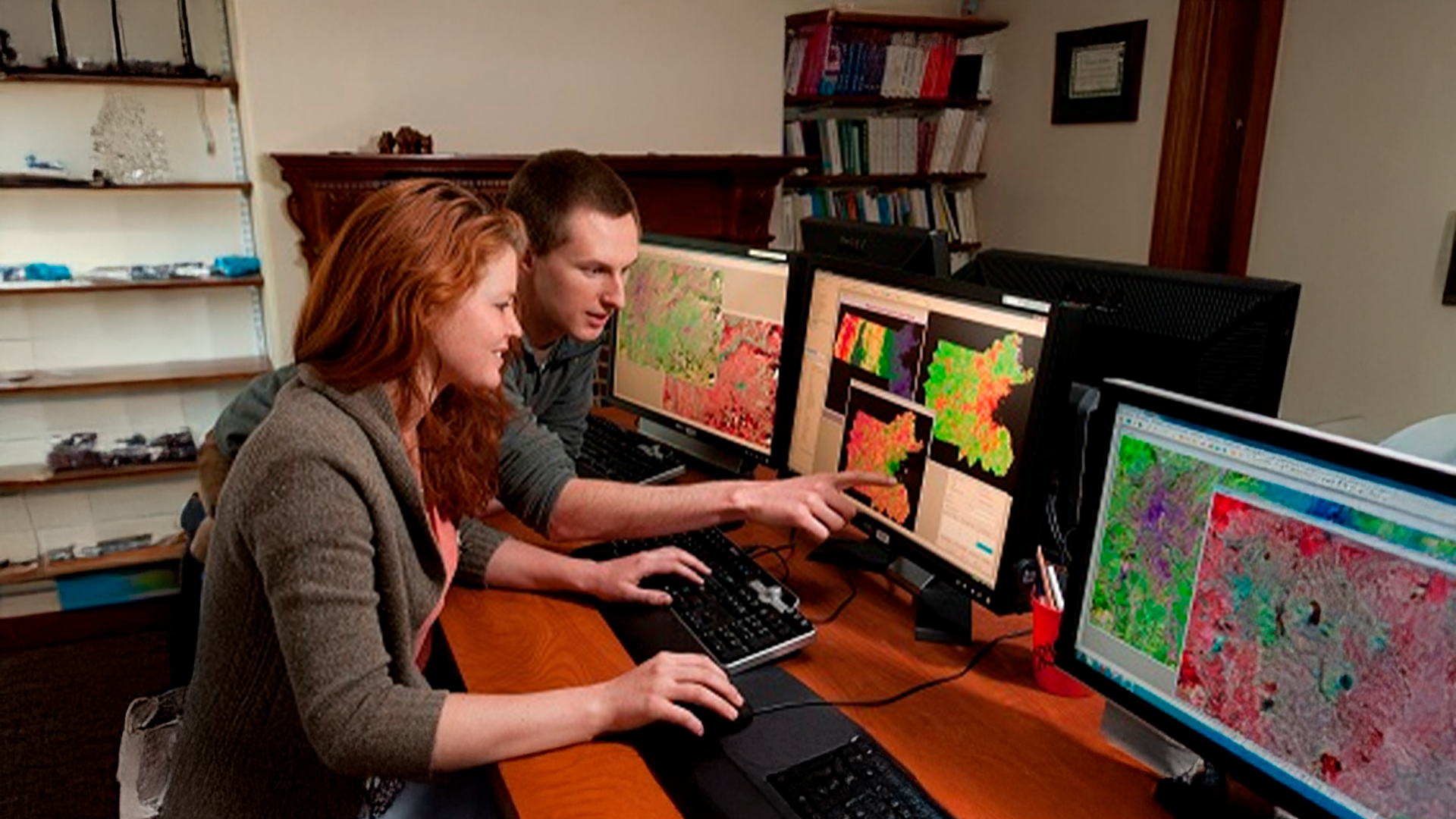 Three young adults smiling while backpacking through a field