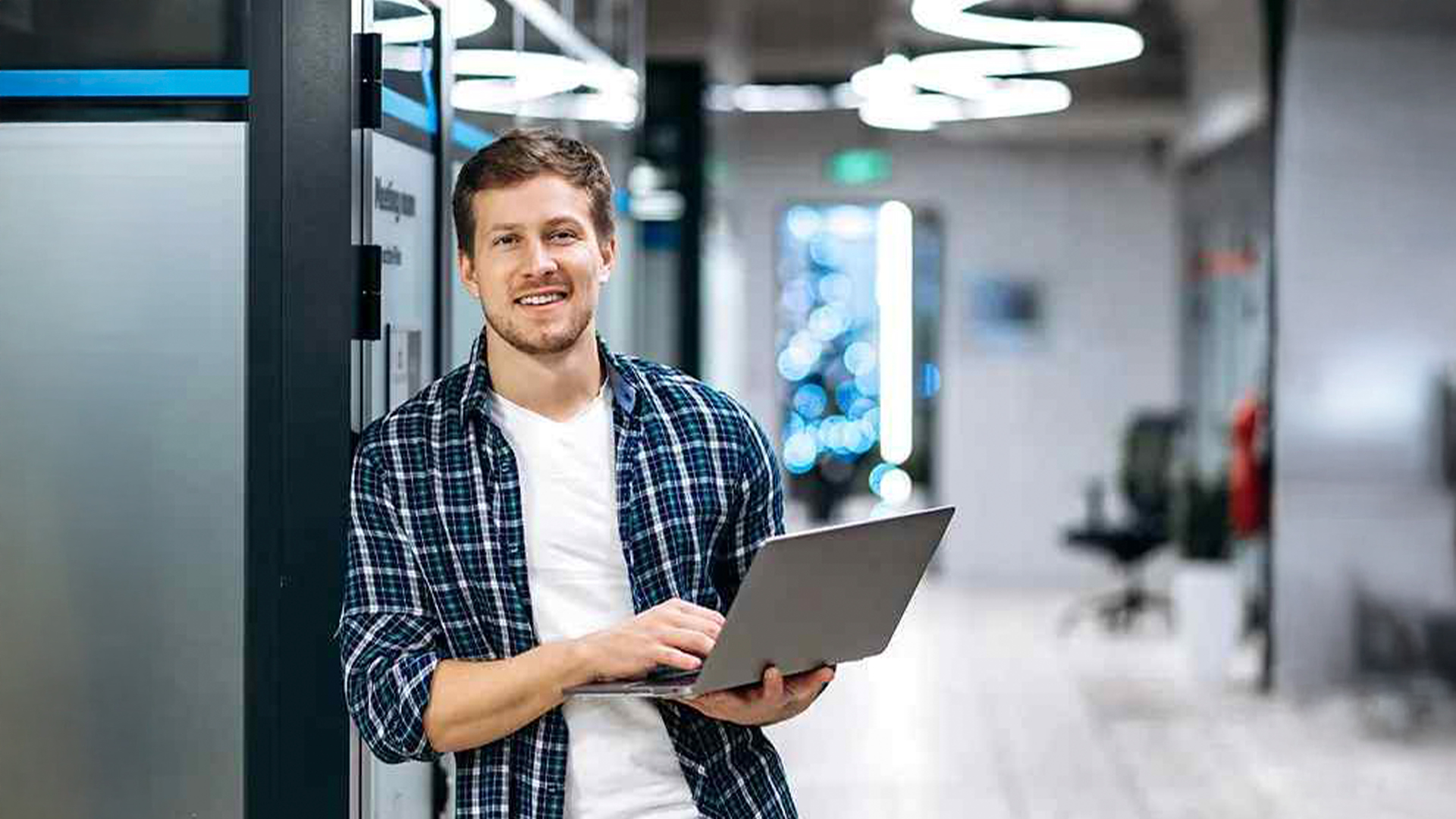Three young adults smiling while backpacking through a field