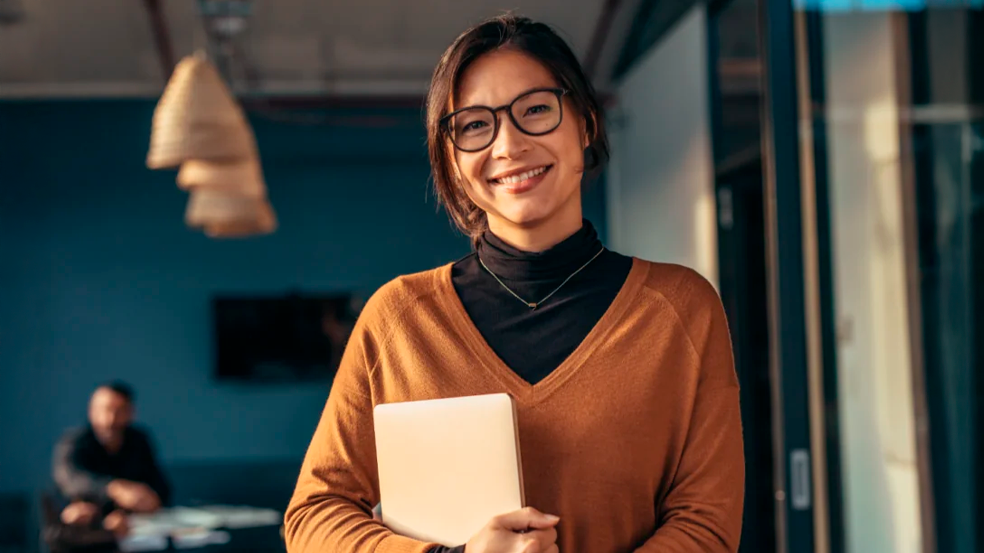 Three young adults smiling while backpacking through a field