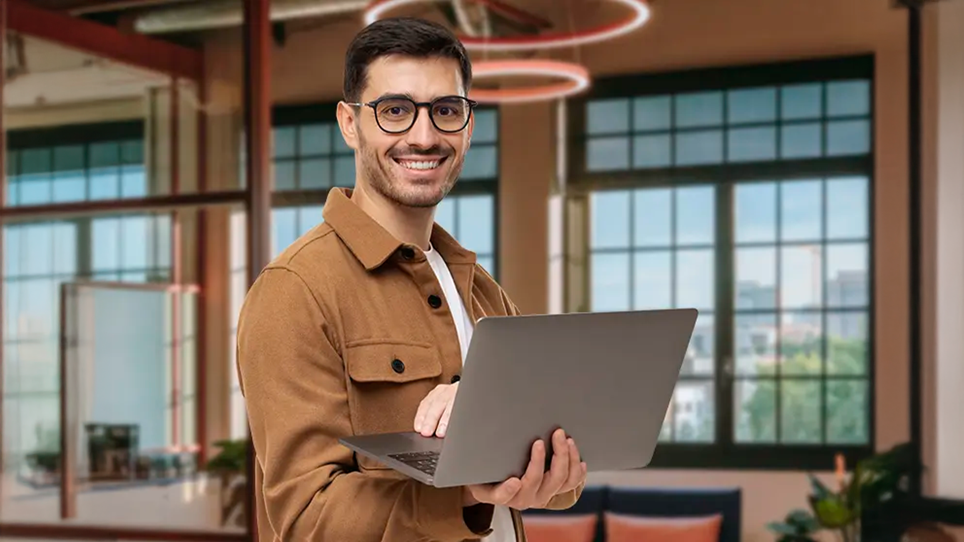 Three young adults smiling while backpacking through a field