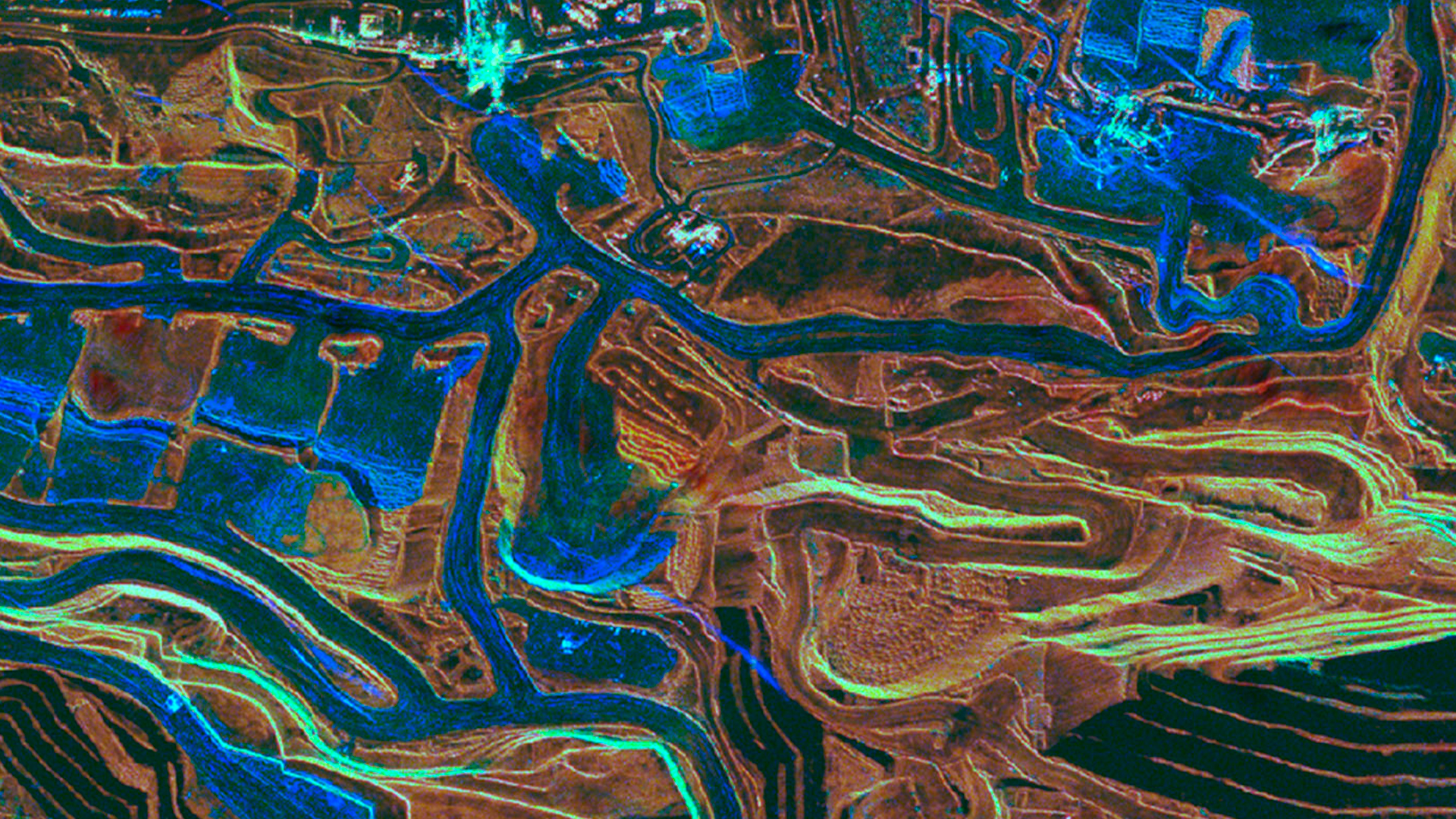 Three young adults smiling while backpacking through a field