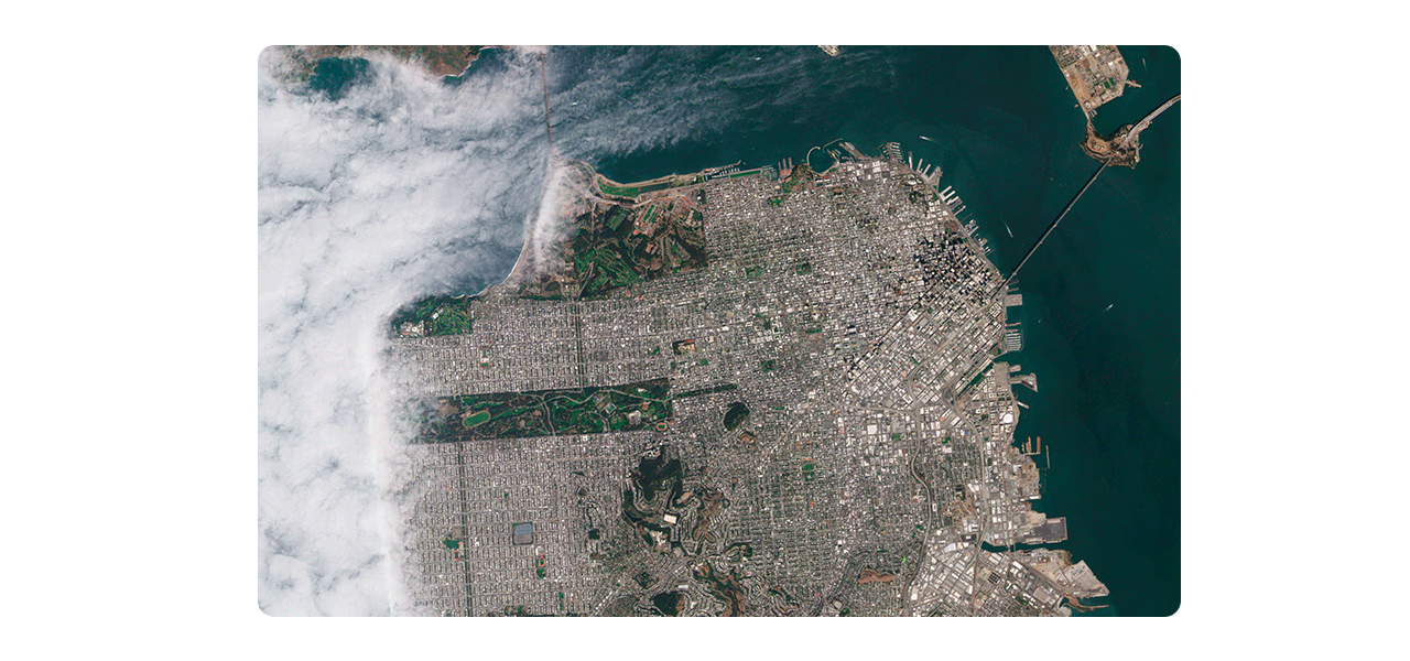 Dos personas que llevan ropa de invierno y equipo de seguridad naranja quitando la nieve acumulada a lo largo de una carretera transitada