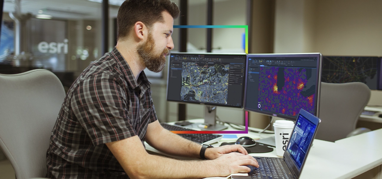 Dos personas que llevan ropa de invierno y equipo de seguridad naranja quitando la nieve acumulada a lo largo de una carretera transitada