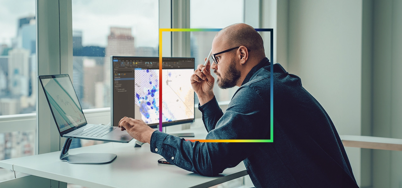 Dos personas que llevan ropa de invierno y equipo de seguridad naranja quitando la nieve acumulada a lo largo de una carretera transitada
