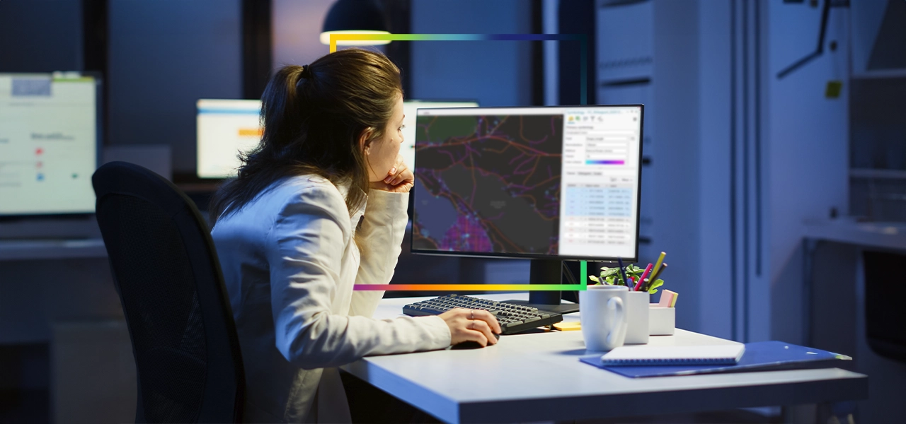 Dos personas que llevan ropa de invierno y equipo de seguridad naranja quitando la nieve acumulada a lo largo de una carretera transitada