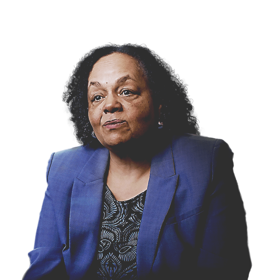 Darlene Flynn, directora ejecutiva de Raza y Equidad de Oakland, con una chaqueta azul sentada frente a un paisaje urbano