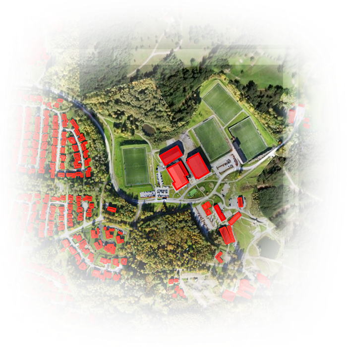 Imagen de satélite de terreno con edificios extraídos coloreados de rojo y tierra y árboles verdes
