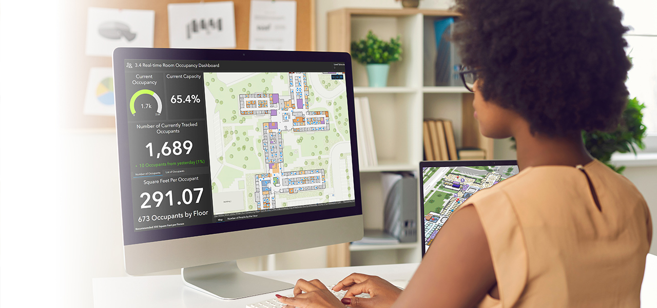 Mujer trabajando en un ordenador visualizando datos de interior con un cuadro de mando con números y mirando mapas de interior