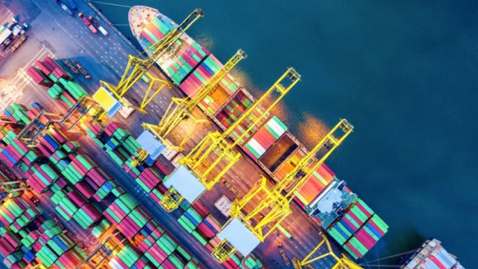 Imagen aérea de un carguero cargado con contenedores en una masa de agua azul