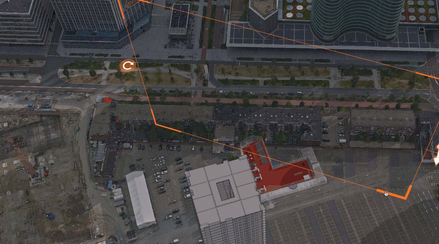 Vista aérea de un modelo de edificio gris alto y un aparcamiento con coches debajo