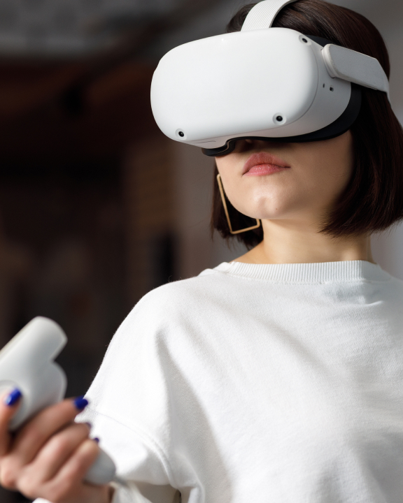 Mujer de pelo castaño corto con camiseta blanca y grandes gafas de XR blancas en los ojos
